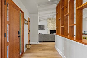 Ein modernes Interieur mit Holztüren, einer Steinsäule und einem grauen Sofa.