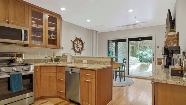 Una cocina moderna con armarios de madera, electrodomésticos de acero inoxidable y una isla grande.
