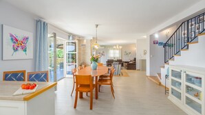 Eine moderne Küche mit Essbereich, einer Treppe und Blick zum Garten.