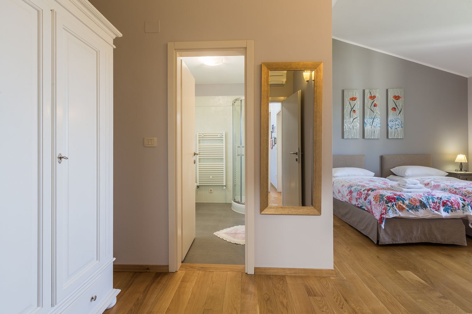 Une chambre à coucher avec un lit, une table de chevet et un miroir.