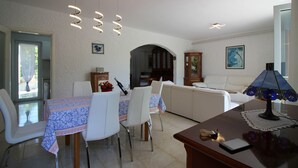 Un comedor con una mesa preparada para cuatro personas, un sofá y una lámpara.