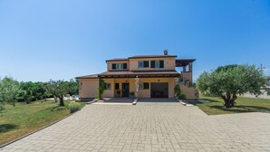 Ein zweigeschossiges Haus mit befestigter Auffahrt und einem kleinen Garten.