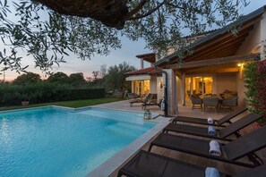 Ein Poolbereich mit Liegestühlen und einer überdachten Terrasse.