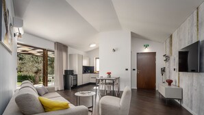 Een moderne woonkamer met een bank, fauteuil en eettafel.