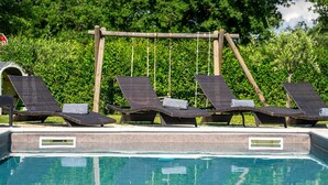 A poolside area with lounge chairs and a wooden swing set. - Pet-friendly villa with private pool, panoramic views and free entry to the Lanterna holiday resort (Tar)