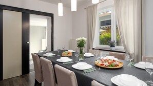 A dining area with a long table set for a meal, featuring a variety of dishes and glasses. - Pet-friendly villa with private pool, panoramic views and free entry to the Lanterna holiday resort (Tar)