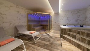 Un moderno spa con una silla de masaje, sauna y bañera de hidromasaje.