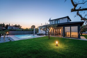 A modern house with a swimming pool, outdoor seating, and a well-maintained lawn. - Impressive villa with sauna, private pool, whirlpool, panoramic sea view (KAŠTELIR)