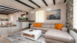 Un salon moderne avec un canapé, une table basse et un tableau représentant une jetée.