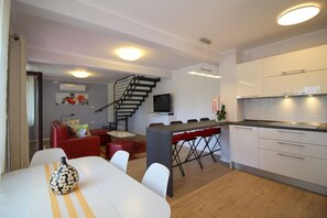 Ein modernes Apartment mit Essbereich, Küche und einer Treppe.