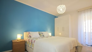 A bedroom with a bed, bedside tables, a hanging light fixture, and a wardrobe. - Idyllic apartment just 700 metres from the beach with balcony, garden and WiFi (Porec)