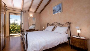 Une chambre à coucher avec un lit, des lampes de chevet, un miroir et un tableau accroché au mur.