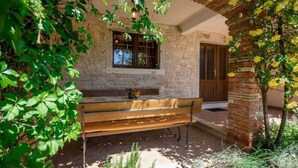 Un bâtiment en pierre avec un banc en bois et une fenêtre.