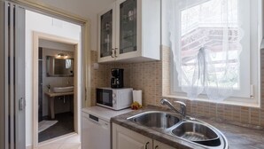 A compact kitchen with a sink, a microwave, and a coffee maker. - Picturesque, dog-friendly holiday home just 400 metres from the beach with BBQ, cot (Porec)