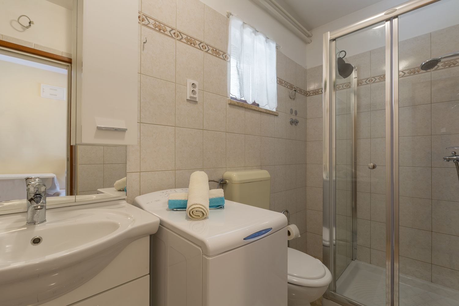 Une salle de bain avec un lavabo, des toilettes et une douche.