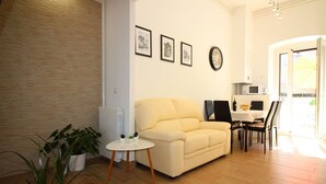 A living room with a sofa, a small round table, and a dining area with chairs and a table. - Fantastic location in the centre of Porec, only 200 metres from the beach with sea views (Porec)