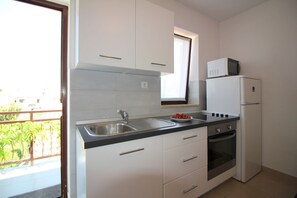 Cafetera o tetera, frigorífico, microondas y placa de cocina