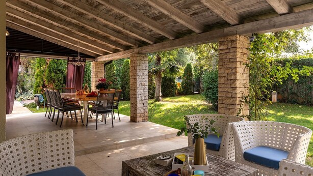 An outdoor patio with stone pillars, wicker furniture, and a dining table. - Dog-friendly villa with private pool, panoramic sea view, outdoor kitchen, cot (Porec)