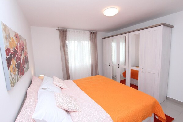 A bedroom with a bed, a wardrobe, and a painting on the wall. - Great apartment with modern furnishings just 300 metres from the centre of Rovinj (Rovinj)