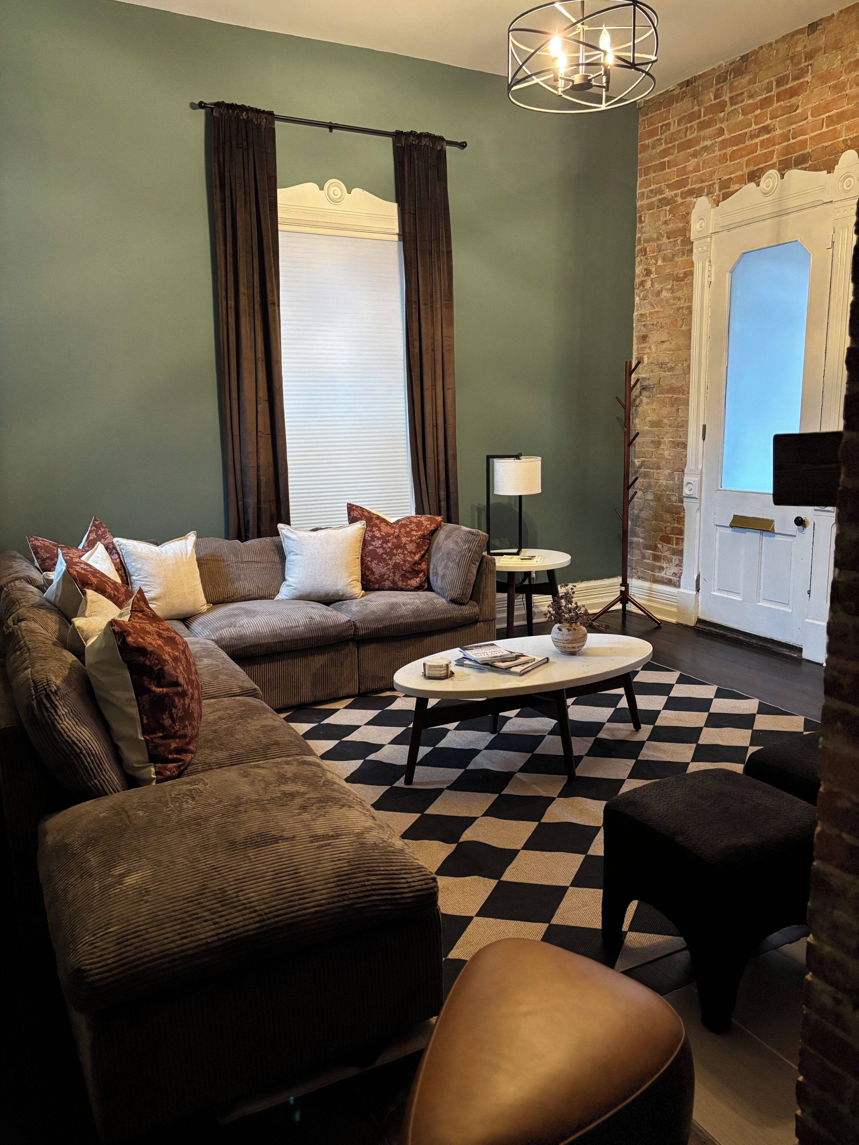 A living room with a sectional sofa, a coffee table, and a checkered rug.