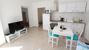 A compact living space with a TV, kitchenette, and dining area. - Fantastic apartment just 400 metres from the beach – pets are welcome (Rovinj)