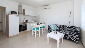 A compact living space with a kitchenette, dining area, and a sofa. - Fantastic apartment just 400 metres from the beach – pets are welcome (Rovinj)