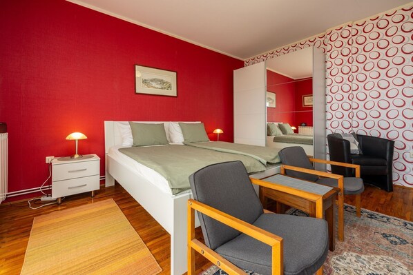 A bedroom with a bed, bedside tables, a chair, a desk, and a mirror. - Picturesque apartment just 500 metres from the beach with sea views, barbecue area, parking space (Crikvenica)