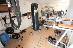 A gym with various exercise equipment, including a punching bag, weight plates, and a bench. - Light-filled apartment just 600 metres from the sandy beach with pool, gym, sea view (Crikvenica)