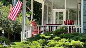 A house with a covered porch, red chairs, and an American flag. - Private 3BR Gem on 2.5 Wooded Acres- Close to All (Sister Bay)