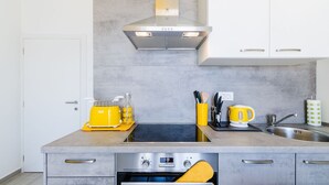 Una cocina moderna con horno empotrado, tostadora y hervidor sobre la encimera.