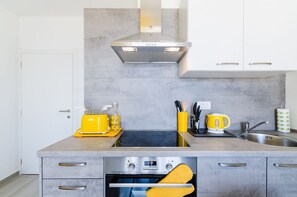 A modern kitchen with a built-in oven, a toaster, and a kettle on the countertop. - Fantastic apartment just 600 metres from the sandy beach with gym, sea view, pool (Crikvenica)