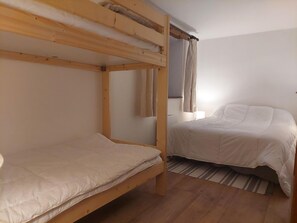 A room with two bunk beds, a window with curtains, and a bed with a white mattress. - Unique chalet 6 guests, southwest terrace, Arc 1800, parking, wifi (Les Arcs 1800)