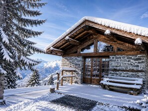 A wooden cabin with a stone facade, large windows, and a snow-covered roof. - Unique chalet 6 guests, southwest terrace, Arc 1800, parking, wifi (Les Arcs 1800)