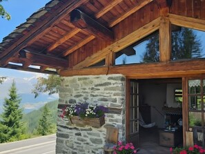 Un bâtiment en pierre avec des poutres en bois, un mur en pierre et une porte en bois.