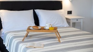 A neatly made bed with a tray of breakfast items, including a croissant, a mug, and a glass of orange juice, on a striped bedspread. - Mediterranean villa with private pool, sea view, dog-friendly, barbecue, private parking (Grižane)