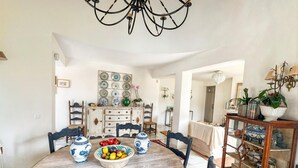 A dining area with a round wooden table, blue and white patterned bowls, and chairs. - Villa Alfredo in Estepona: 4 bedrooms near the beach (Estepona)