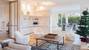 A modern living room with a sofa, chairs, a coffee table, and a dining area with a table and chairs. - Spacious villa in quiet area with garden and Wi-Fi in Le Touquet (Le Touquet-Paris-Plage)