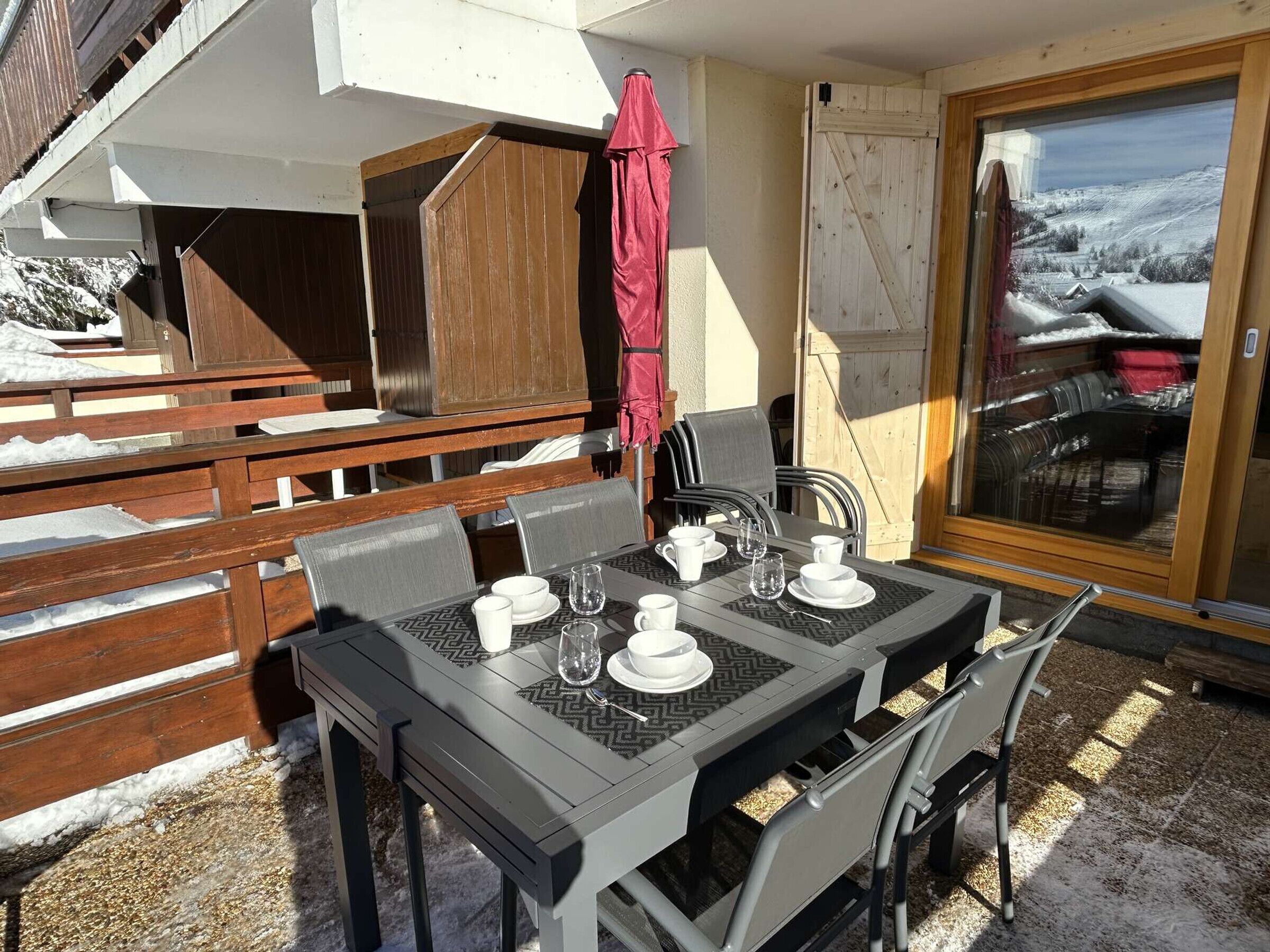 Een eetgedeelte met een tafel voor vier personen, omringd door houten banken en stoelen.