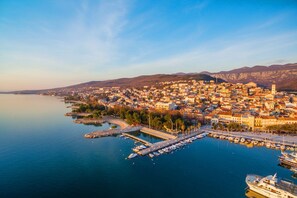 An aerial view of a coastal town with a marina, buildings, and hills in the background. - Idyllic apartment with parking space, WiFi, air conditioning, washing machine (Crikvenica)