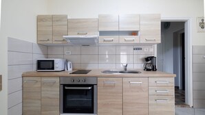 Una cocina compacta con horno integrado, microondas y tostadora.