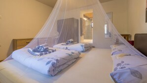 Ein Schlafzimmer mit zwei Betten, einem Baldachinbett und einem Nachttisch.
