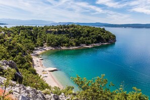A coastal landscape with a beach, clear turquoise waters, and a forested hill. - Cosy apartment just 250 metres from the beach with sea view, private parking, WiFi (Dramalj)