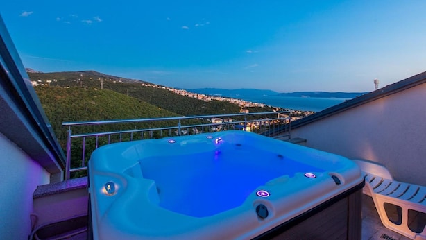 Ein Whirlpool mit weitreichendem Blick auf eine Küstenstadt und Berge.