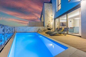 An outdoor swimming pool with lounge chairs and a stone wall. - Stunning villa on Liebespfad with private pool, sea view, mosquito nets, BBQ area (Crikvenica)
