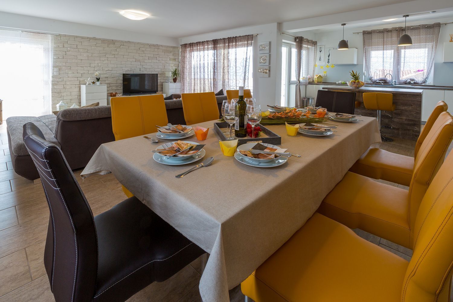 A dining area with a table set for four, surrounded by yellow chairs.