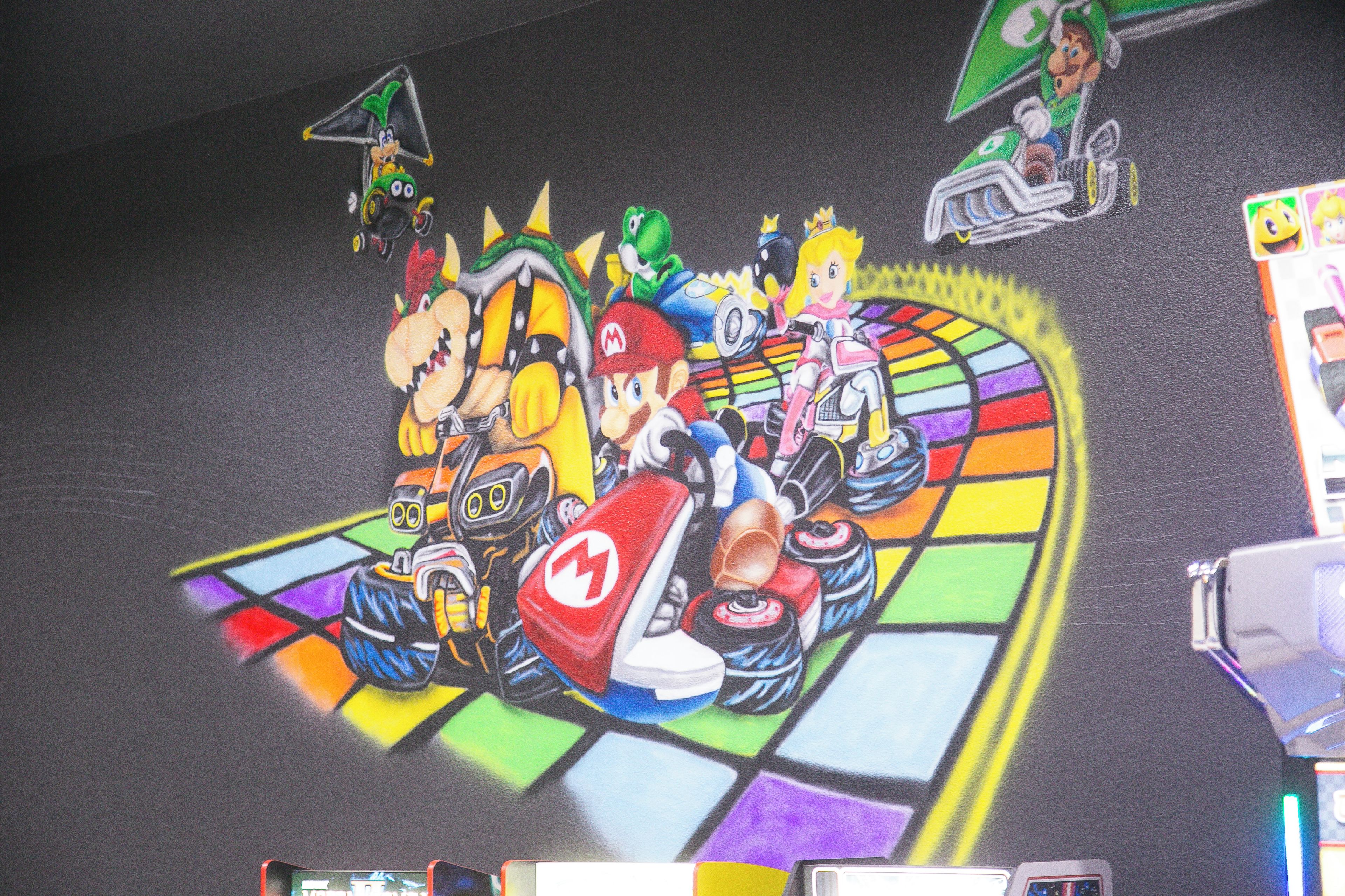 Una pared con un mural de carreras de Mario Kart lleno de color.