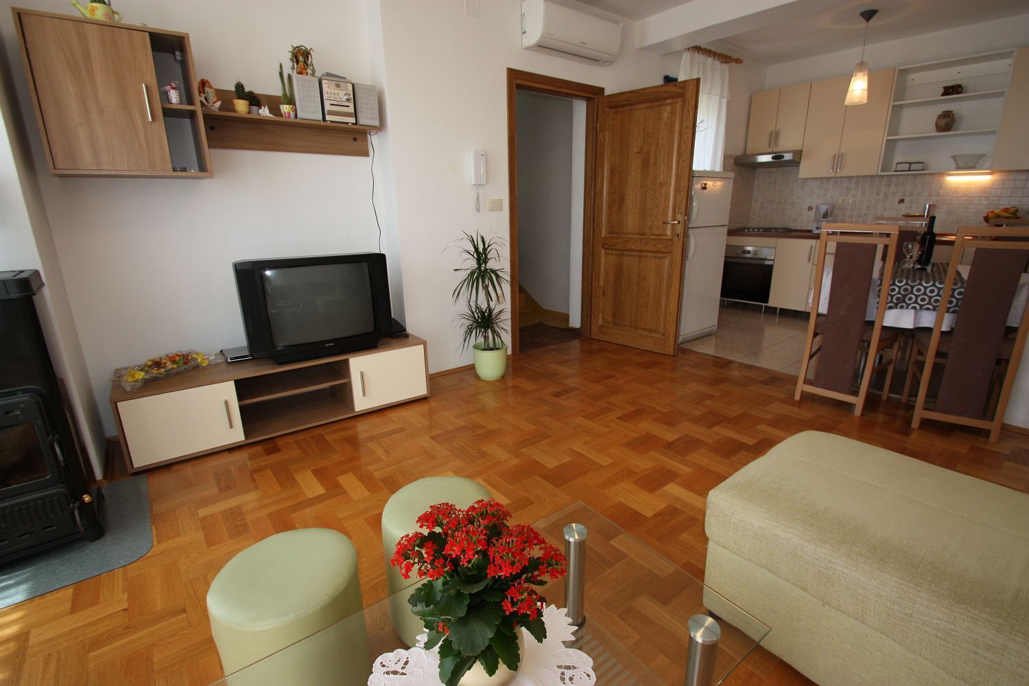 A compact living space with a TV, kitchenette, and seating area.