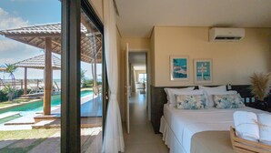 A hotel room with a bed, a window, and a view of a pool and outdoor area. - Villa Sumatera Beach (Trairi)