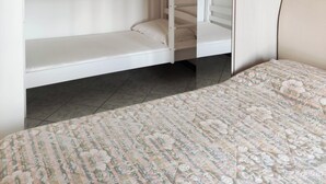 A bedroom with a bunk bed, a large mirror, and a floral bedspread. - Apartment With sea View Balcony (Jesolo)