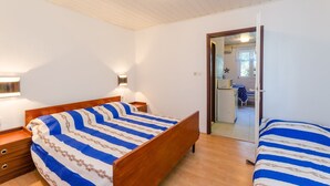 Une chambre avec deux lits, des têtes de lit en bois et une petite table de chevet.